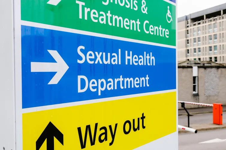 A hospital sign pointing to a sexual health clinic.