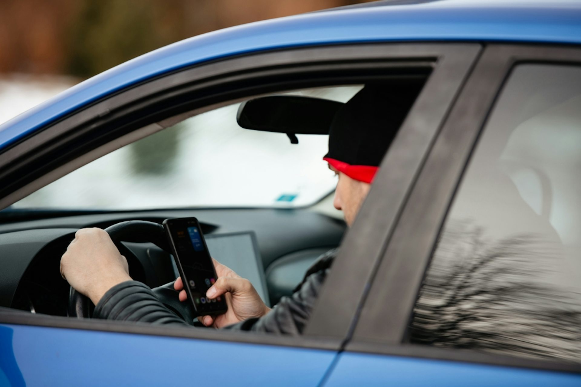 Man looking at his phone while driving.