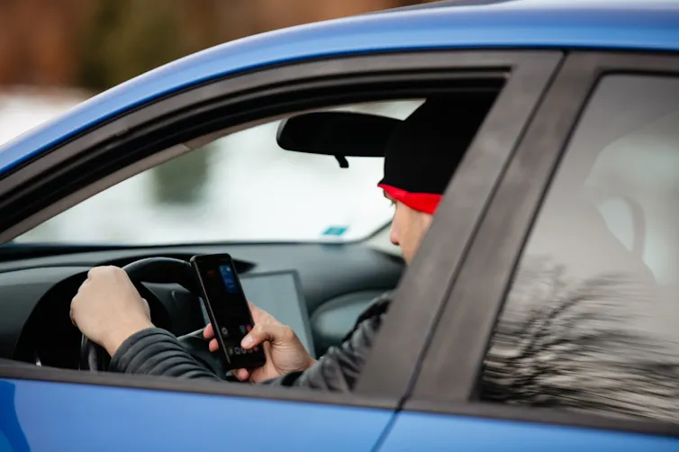 Man looking at his phone while driving.