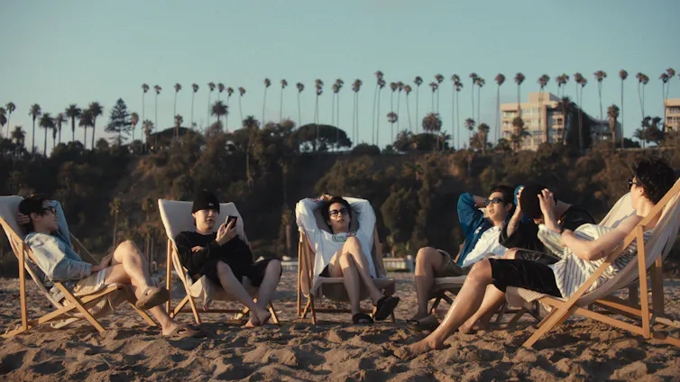 BTS: The Go back presentations an international band renegotiating id and nationhood 1 j-hope, Suga, Jin, RM, Jung Kook and Jimin sitting on the beach