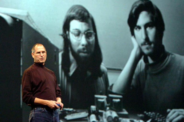 Steve Jobs speaking in January 2006 in front of a photo of himself with Apple's co-founder, Steve Wozniak.