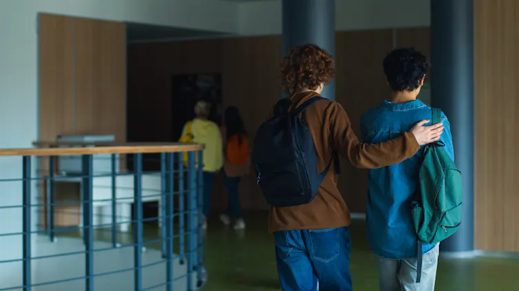 Two boys in a school corridor.