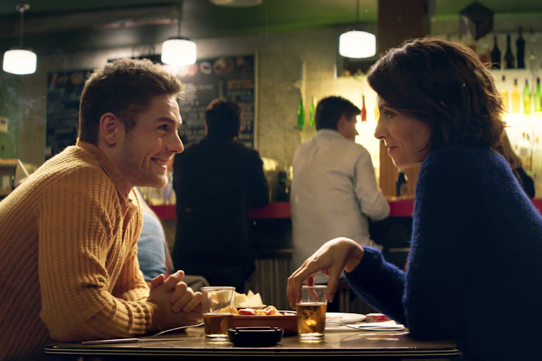 A man and a women sitting and talking at a table.