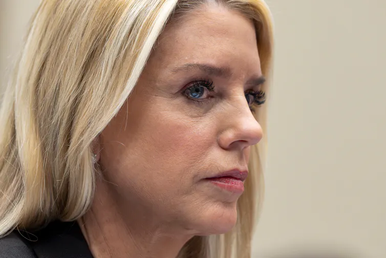 A blond-haired woman looks stern.