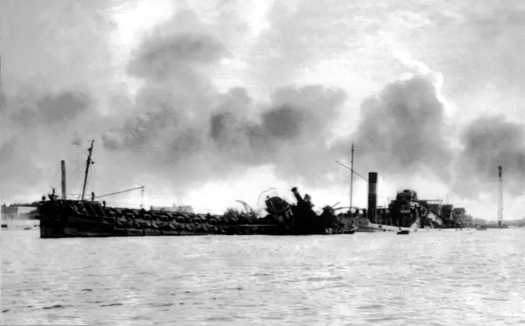 Partially sunken ships block a waterway.