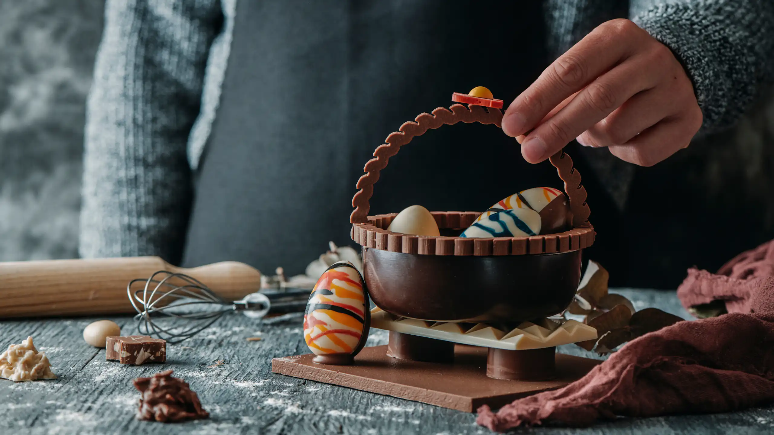 Una mona de Passqua de xocolata amb forma de cistella i ous dins.