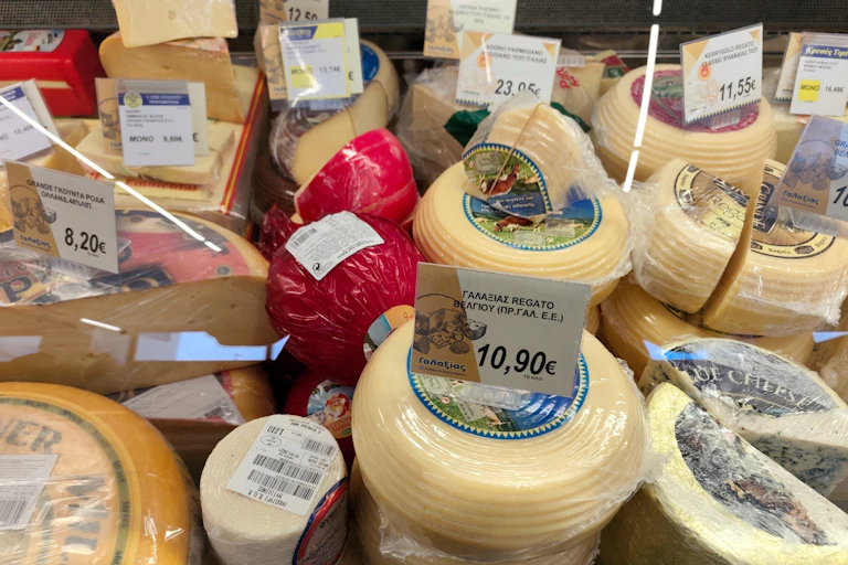 selection of cheeses on a deli counter at a greek supermarket