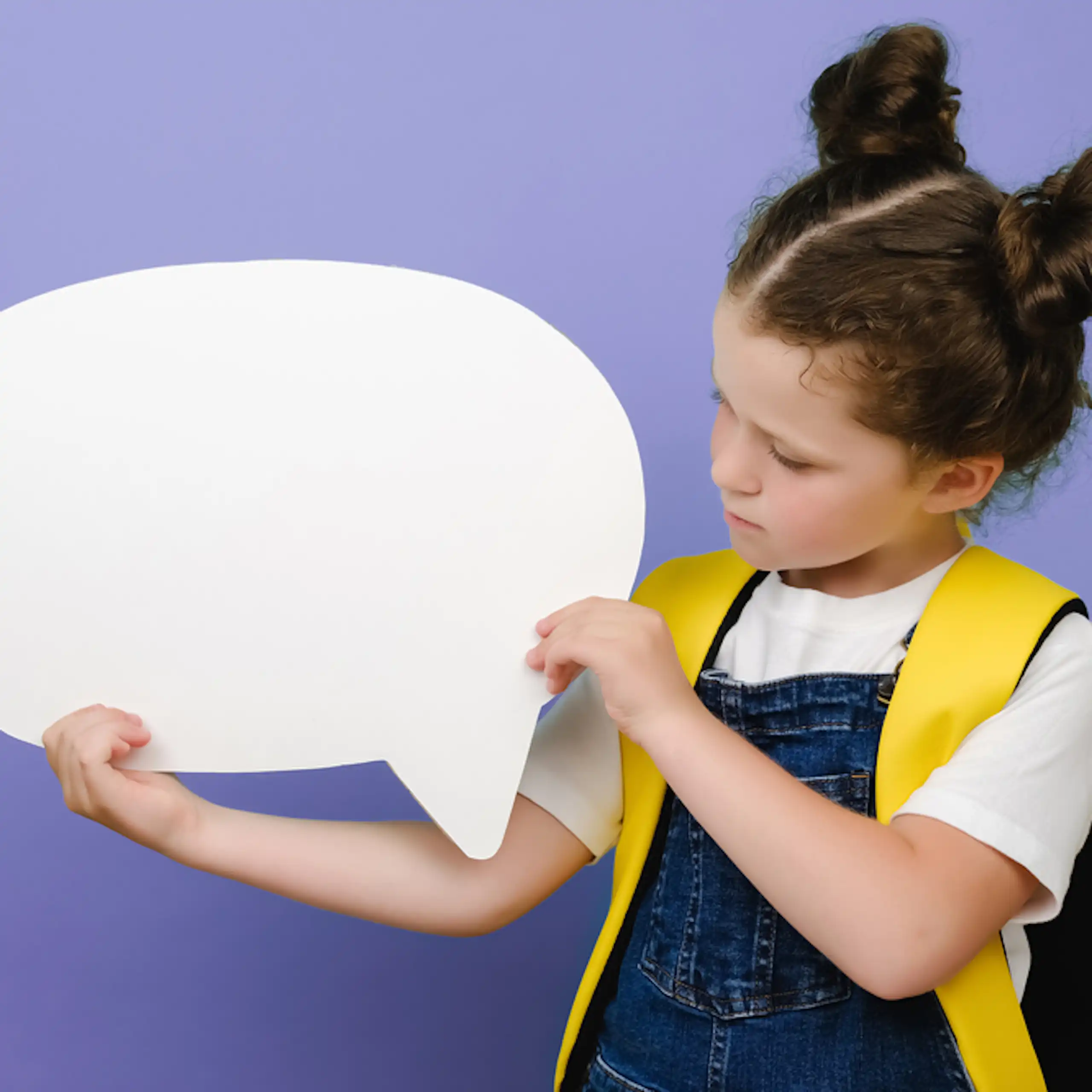 Une petite fille avec un cartable tenant une bulle.