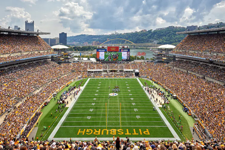 A football stadium filled with hundreds of thousands of people during the day.