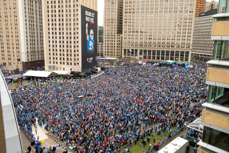 Large crowd in the middle of a city during the day.
