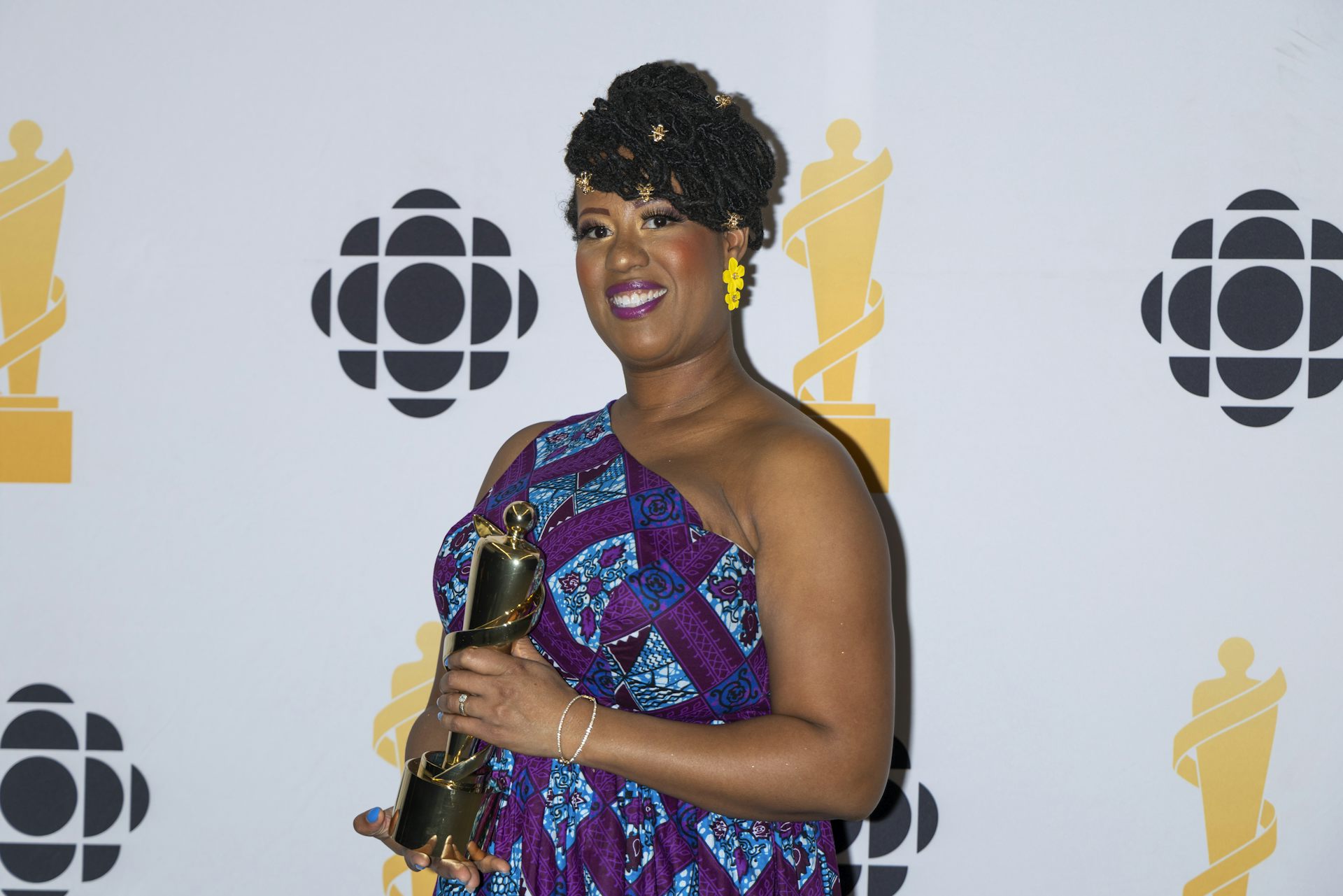 A person in a fancy dress holding a trophy award.