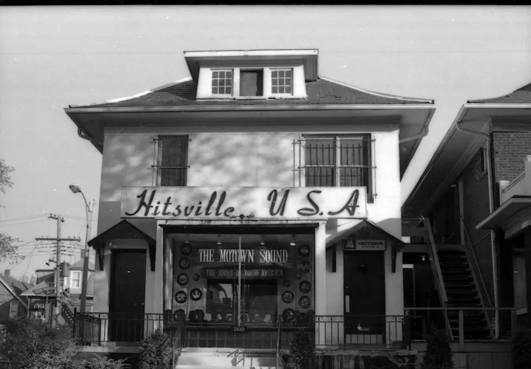 A solidly build residence has a sign reading 'Hitsville USA' across the facade.