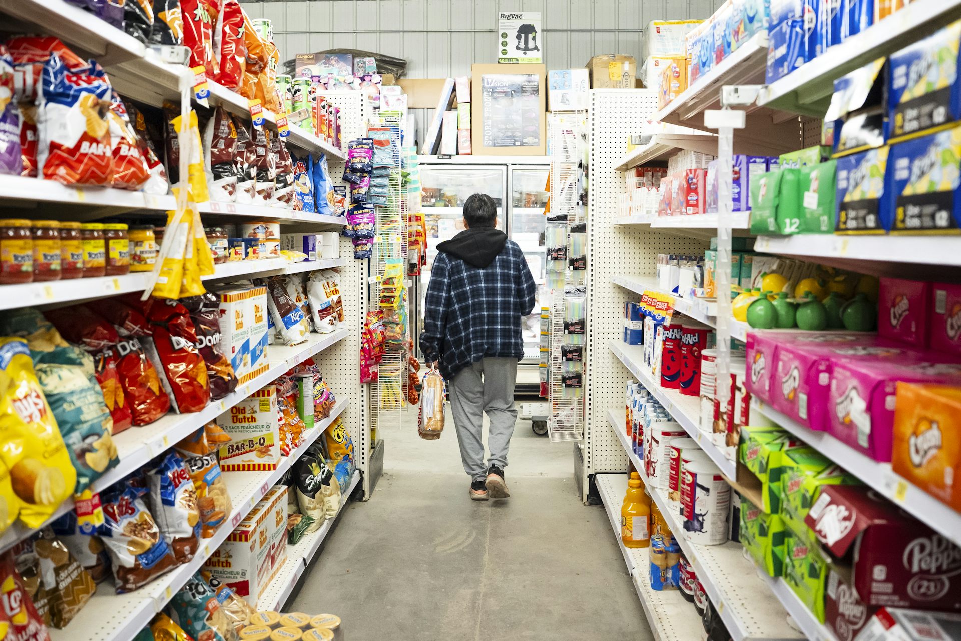 Una persona camina por el pasillo de una tienda de comestibles.