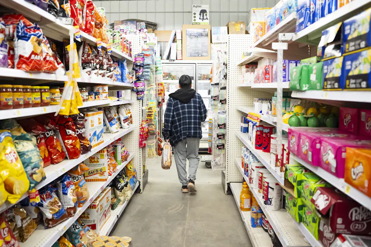 A person walks down the aisle of a grocery store