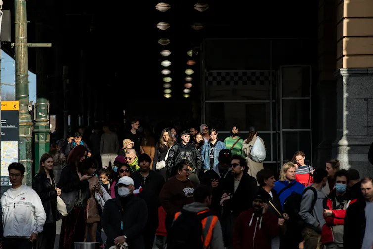 A crowd of commuters walking in and out of Melbourne's Flinders Street station.