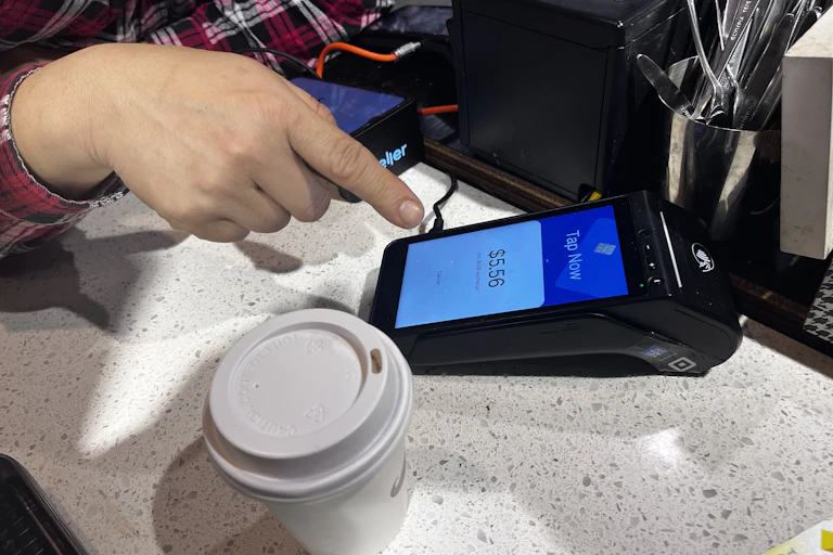 Someone about to pay for a coffee at a Sydney cafe