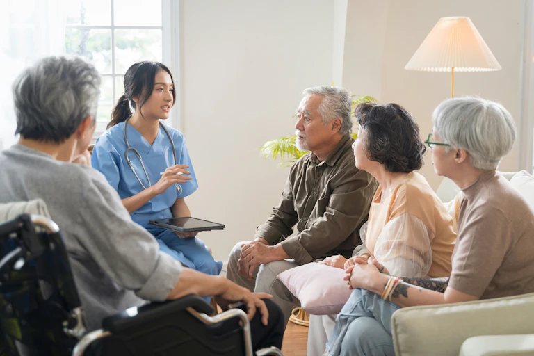 A group of older adults and a younger woman in scrubs with a stethoscope and clipboard