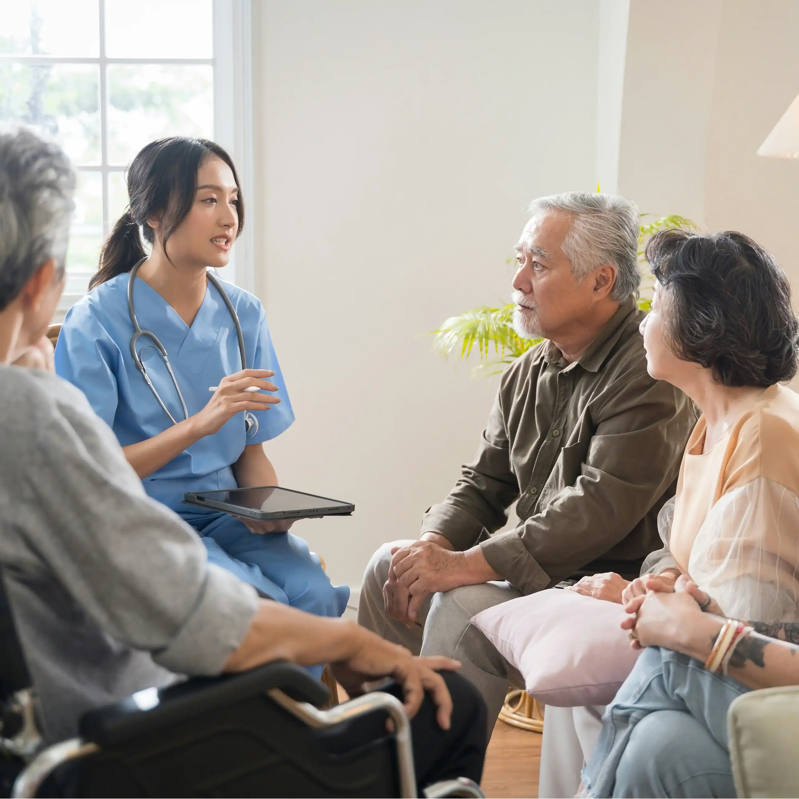 A group of older adults and a younger woman in scrubs with a stethoscope and clipboard