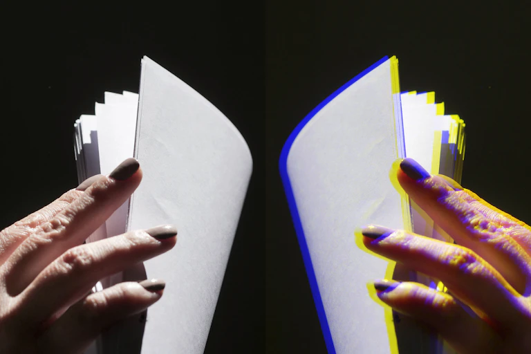 A close up shot of a person's hand flicking through pages of paper.