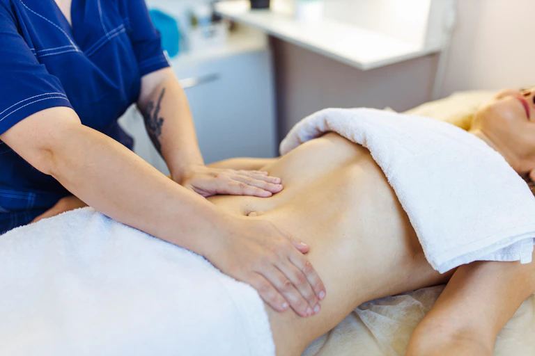 Woman receives a massage on her stomach.