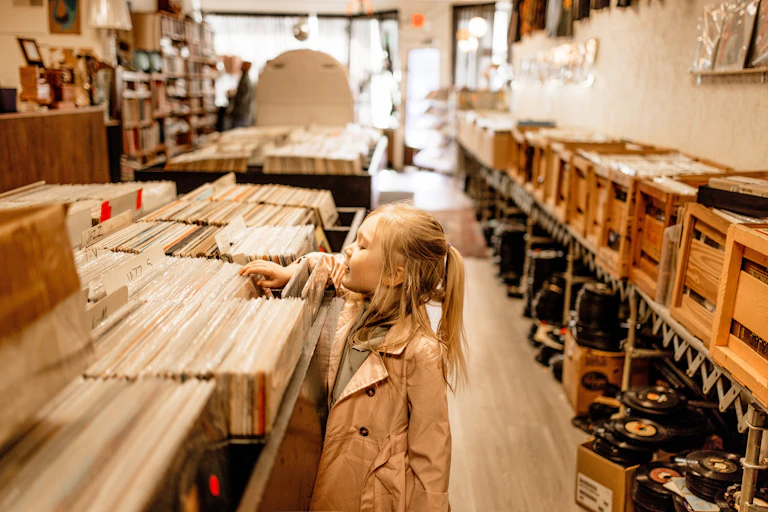 Una niña revisa vinilos en una tienda.
