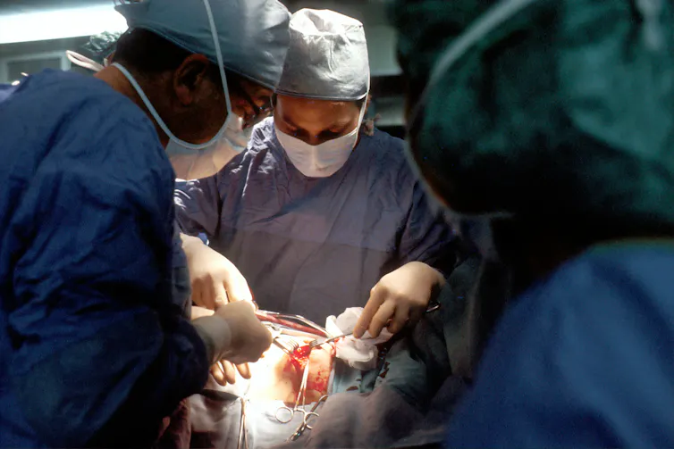 Des médecins pratiquent un acte chirurgical sur un patient