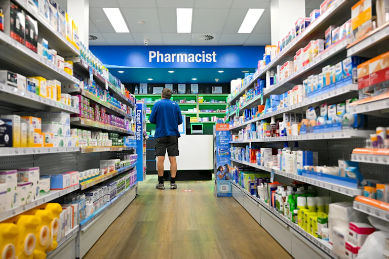 Man waits to get his prescription filled at a pharmacy