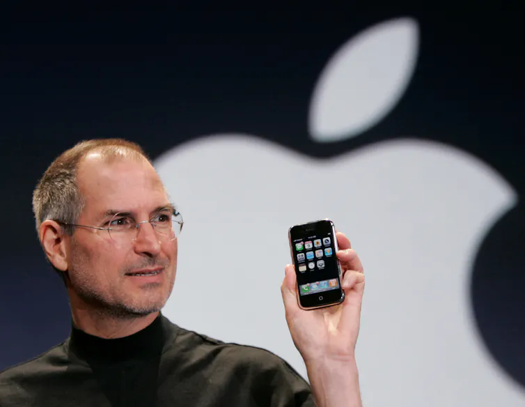 Apple chief executive Steve Jobs holds up an Apple iPhone