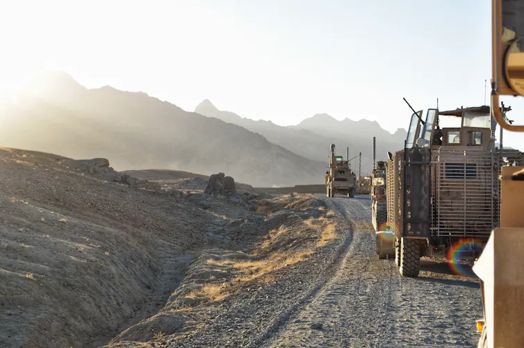 A convoy of armoured vehicles patrol a mountainous area of Afghanistan.