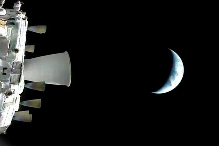 The Earth seen from a distance in space. Only a crescent of it is visisble; the rest is in shadow