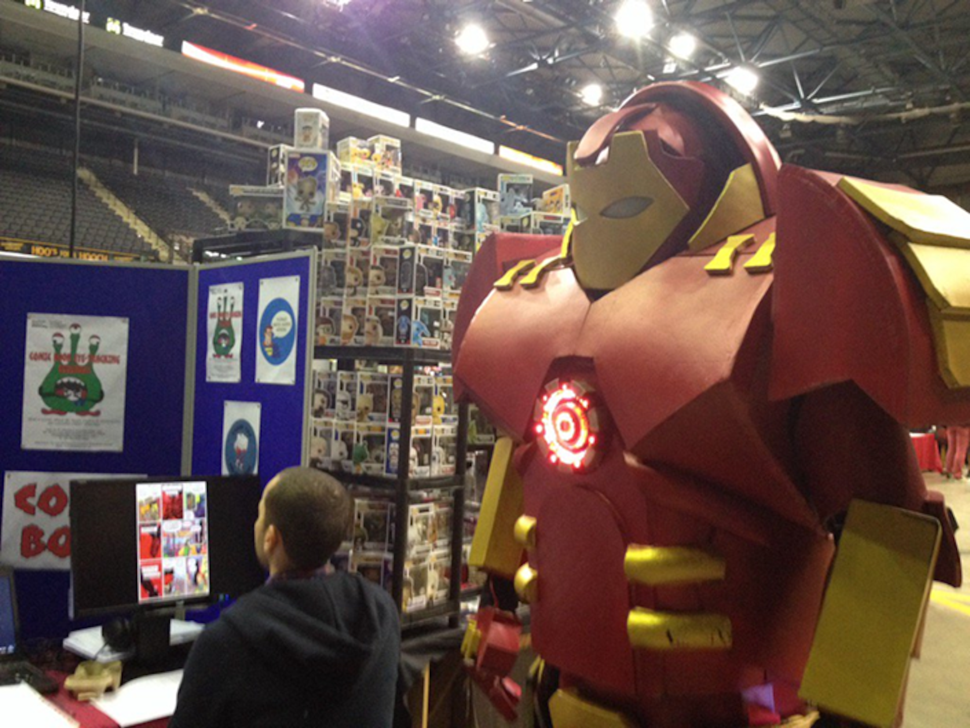 An enormous Iron-man cosplayer looming over a participant in an eye-tracking study at a comic convention