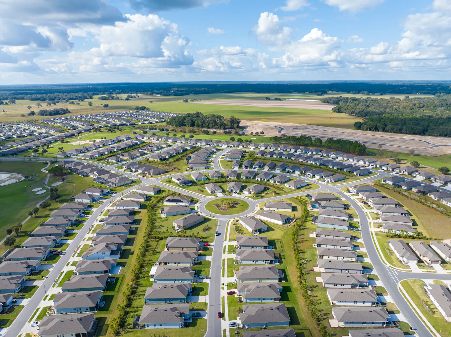 A suburban neighborhood in Florida abuts open fields and forested areas