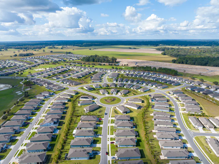 A suburban neighborhood in Florida abuts open fields and forested areas