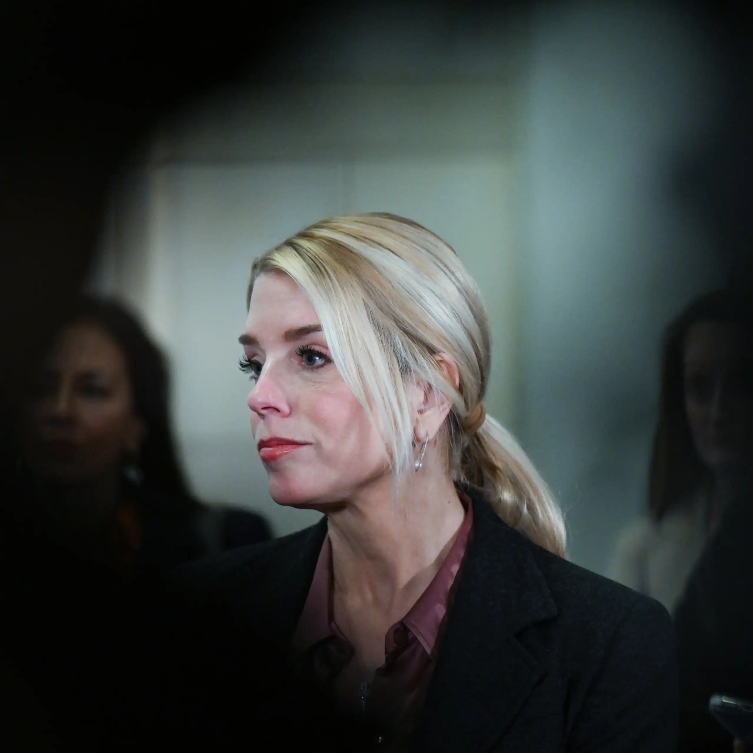 A woman in a building stares into the distance.