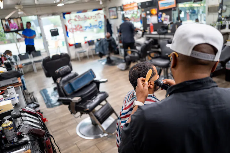 A barber gives a man a haircut.