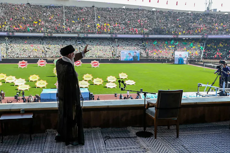 Un hombre saluda a una gran multitud en un estadio de atletismo