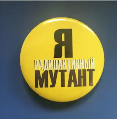 pin con fondo amarillo con escritura cirílica en blanco y negro