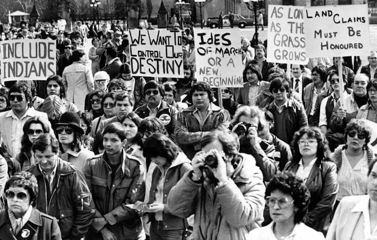 A black and white photo shows protesters, some holding signs