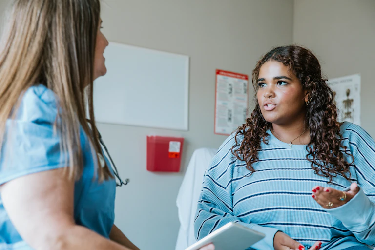 Young woman talks to her health care provider about UTI symptoms