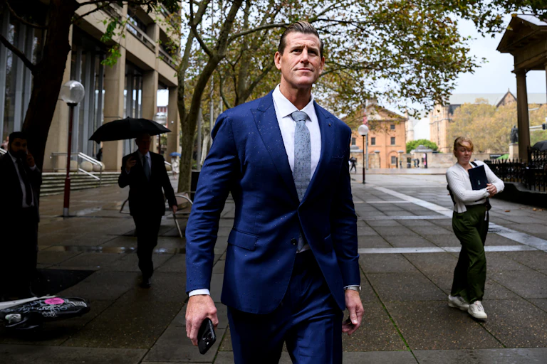 A man in a suit walks across a courtyard