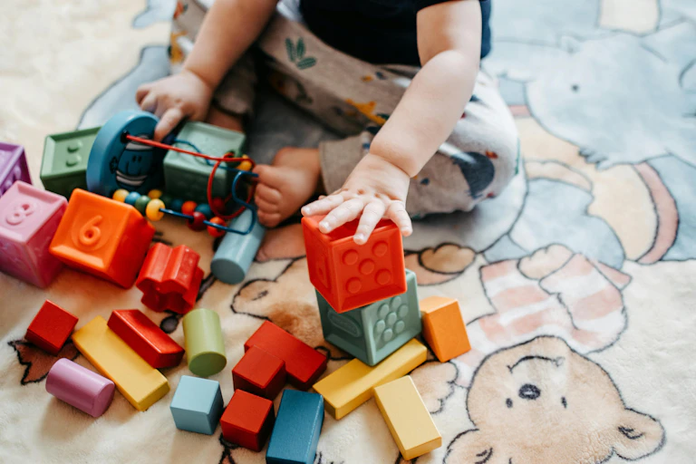 A baby's hands playing with colourful blocks.