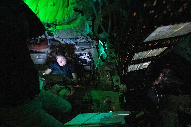 Una mujer en una estancia oscura con la cara iluminada
