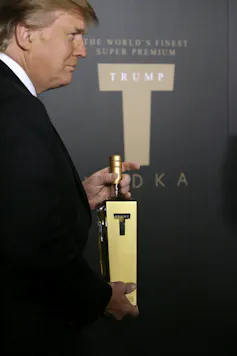 Donald Trump tient une bouteille de Trump Vodka