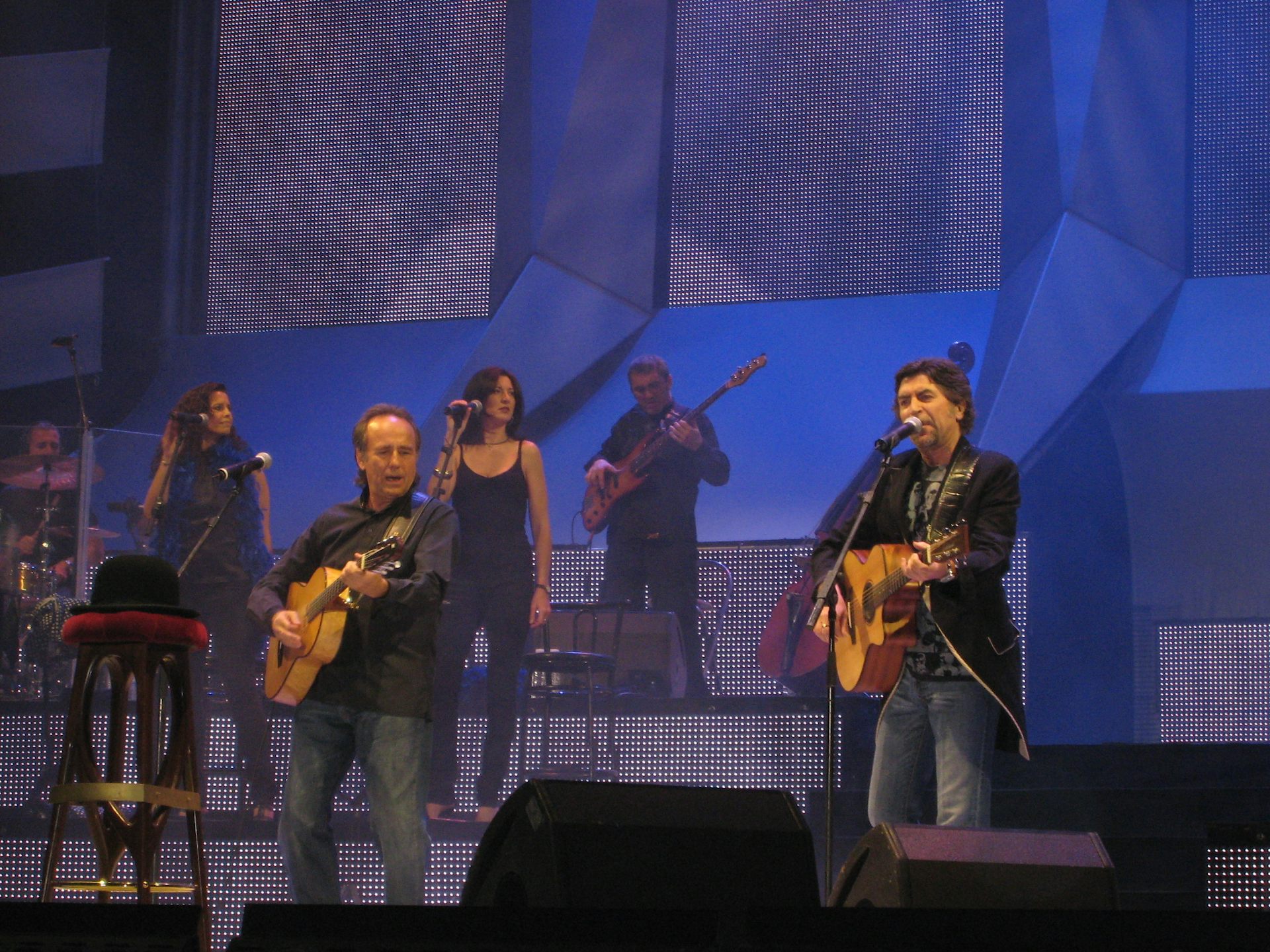 Dos hombres tocan la guitarra en un escenario.
