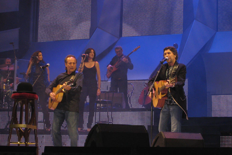 Dos hombres tocan la guitarra en un escenario.