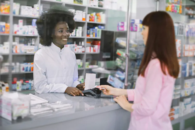 A pharmacist talking to a customer