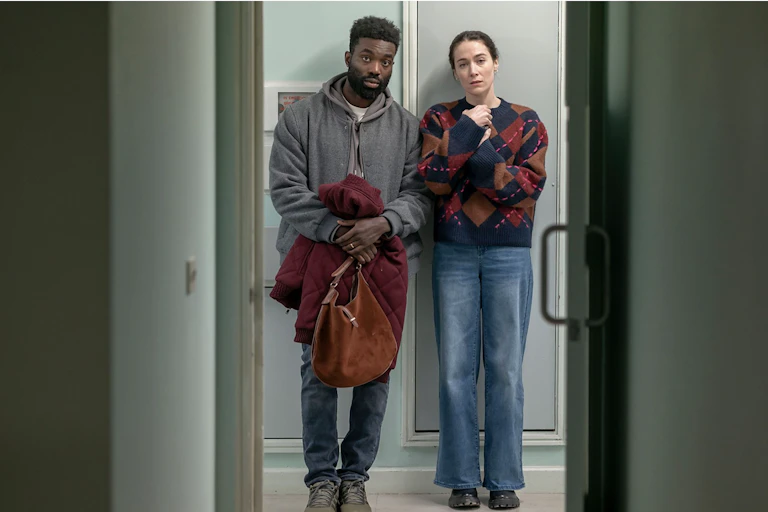 A young couple looking apprehensive inside a hospital.