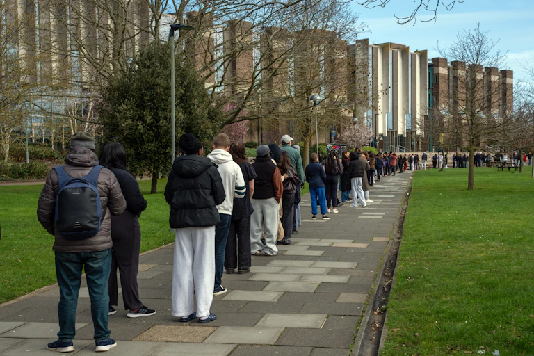 Students and staff queue to receive antibiotics at the UK University of Kent