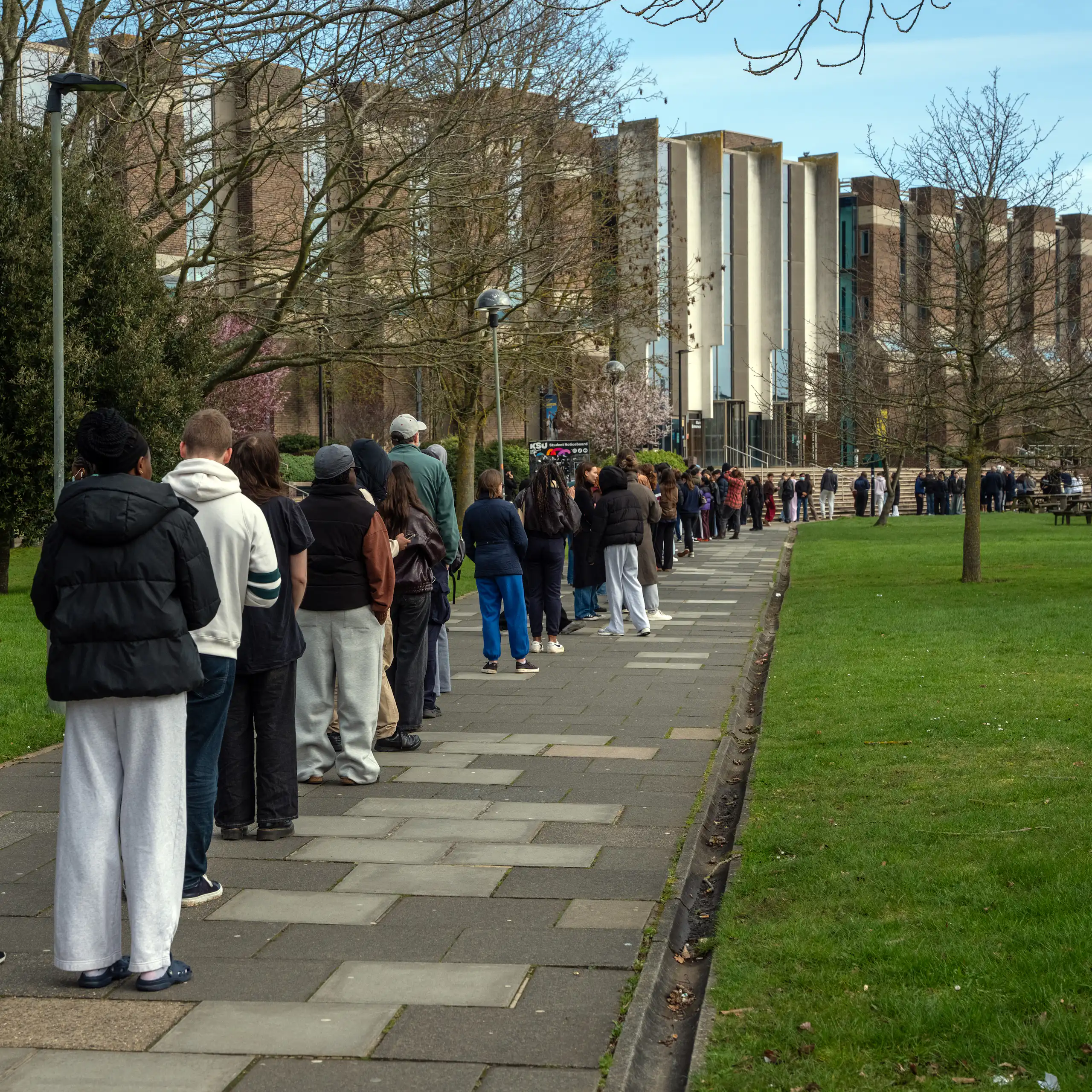 Students and staff queue to receive antibiotics at the UK University of Kent
