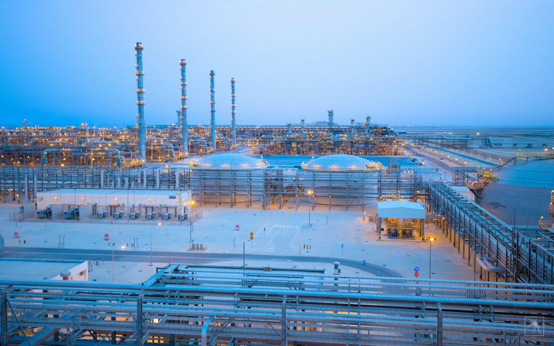 a sprawling industrial plant with smoke stacks and pipelines